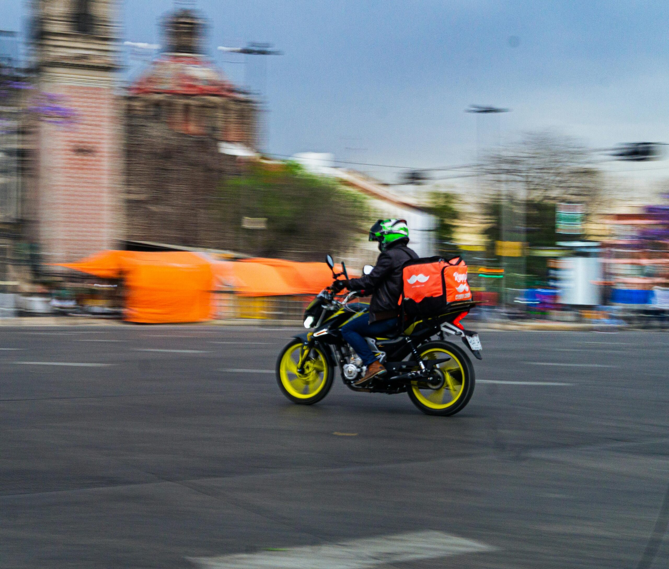 Motorcyclist delivering food in bustling Ciudad de México, showcasing urban vibrancy and efficiency.